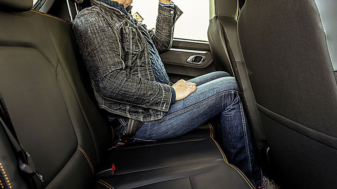 Ein Mann sitzt auf der Rückbank eines Autos, aber ist das auch der sicherste Platz im Auto?