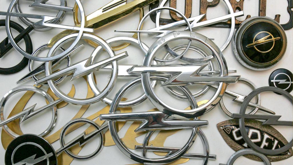 Mehrere Generationen des Opel-Logos auf einen Blick