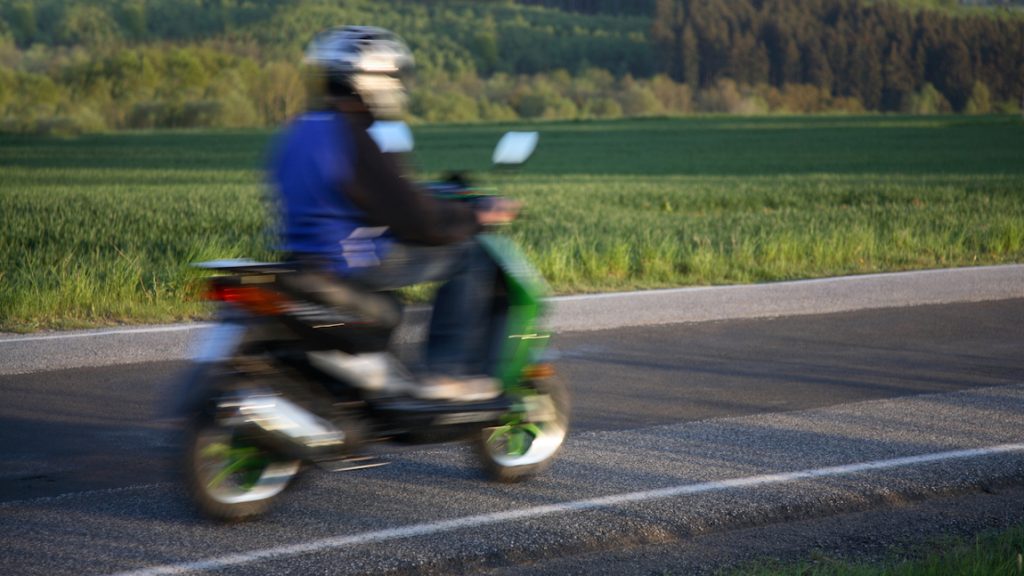 Ein Mopedfahrer auf einem Moped mit einem Mopedführerschein in der Tasche, hoffentlich.